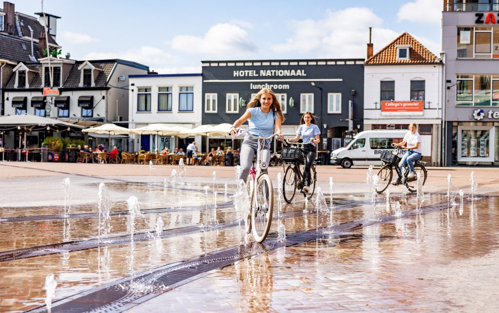 meisjes fietsen door de fonteinen